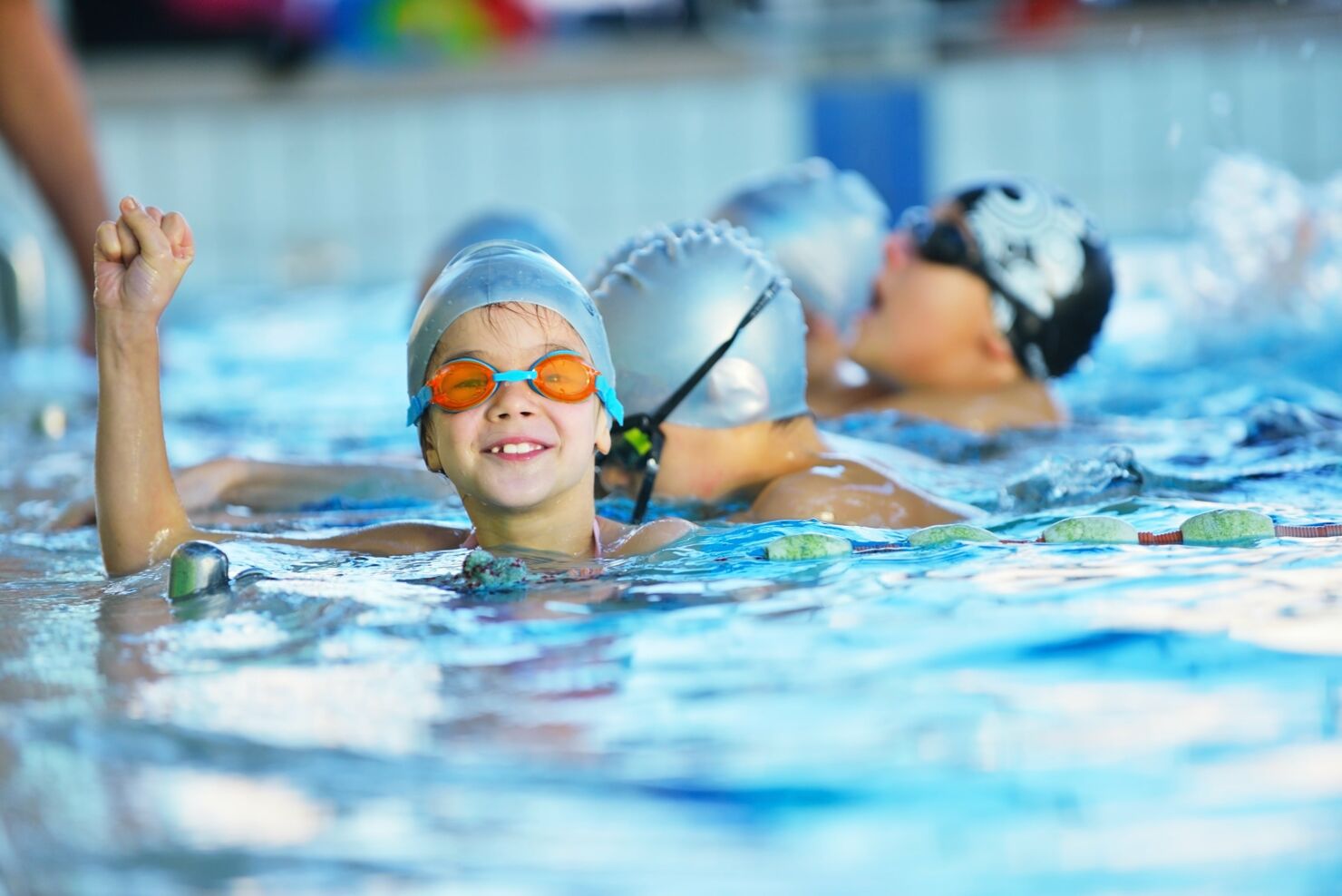 Es schwimmen mehrere Kinder im Schwimmbad